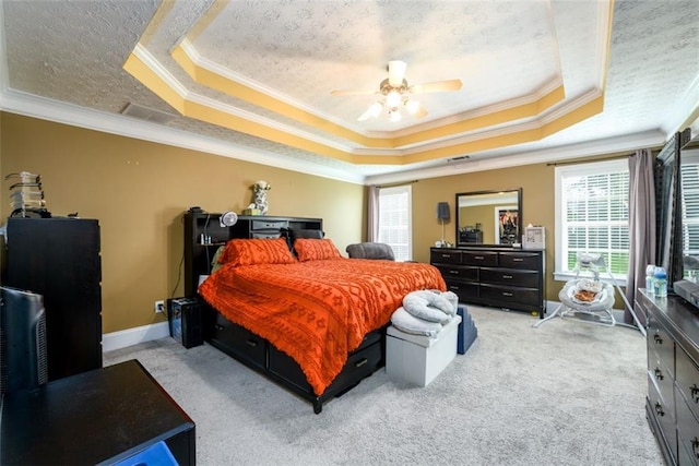 carpeted bedroom featuring a tray ceiling, baseboards, a textured ceiling, and crown molding