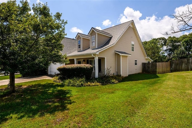 view of home's exterior featuring a yard, driveway, an attached garage, and fence