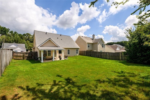 back of house featuring a fenced backyard, a patio, and a yard