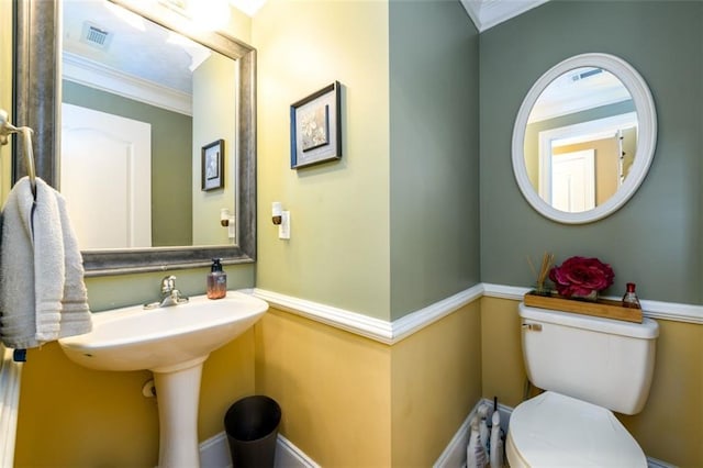 half bath with visible vents, toilet, and crown molding