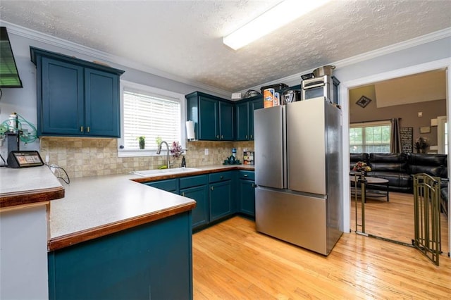 kitchen featuring light wood-style floors, freestanding refrigerator, and ornamental molding