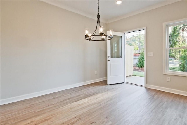 empty room featuring baseboards, ornamental molding, light wood-style floors, a chandelier, and recessed lighting