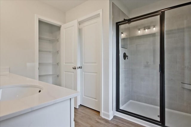 bathroom with a stall shower, wood finished floors, and vanity