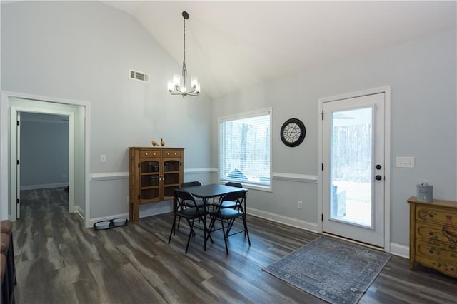 dining space with dark hardwood / wood-style flooring, vaulted ceiling, and a chandelier