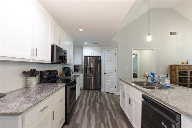 kitchen featuring lofted ceiling, backsplash, black appliances, white cabinets, and decorative light fixtures