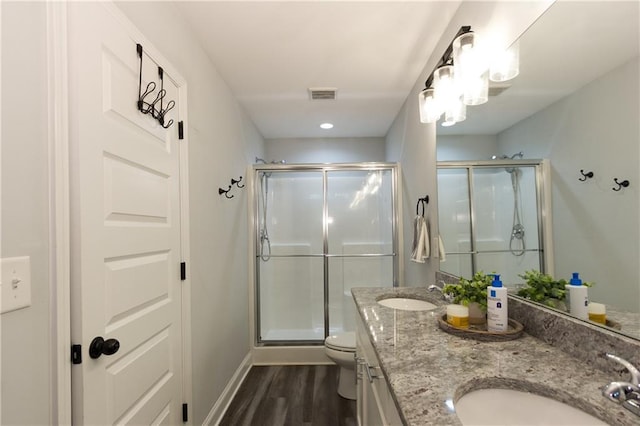 bathroom featuring walk in shower, vanity, toilet, and hardwood / wood-style flooring