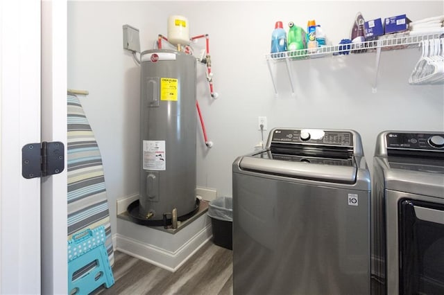 washroom with electric water heater, dark wood-type flooring, and washer and clothes dryer