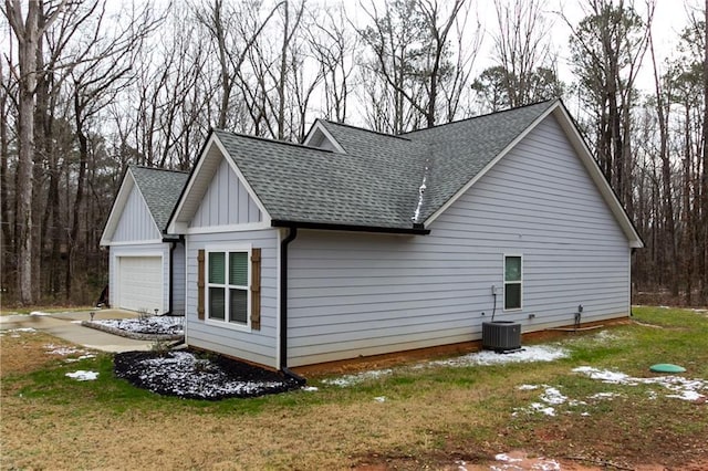 view of home's exterior featuring a garage, a lawn, and central air condition unit