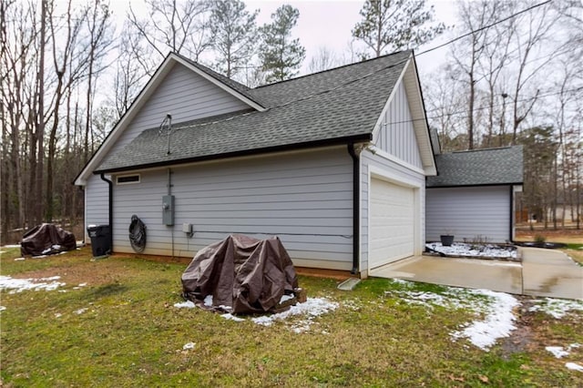 view of side of home featuring a garage and a lawn