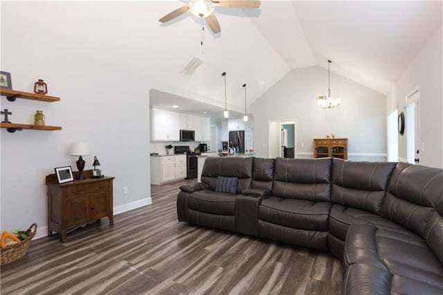 living room featuring ceiling fan with notable chandelier, dark hardwood / wood-style floors, and vaulted ceiling