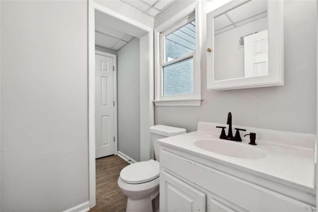 bathroom with hardwood / wood-style flooring, vanity, and toilet