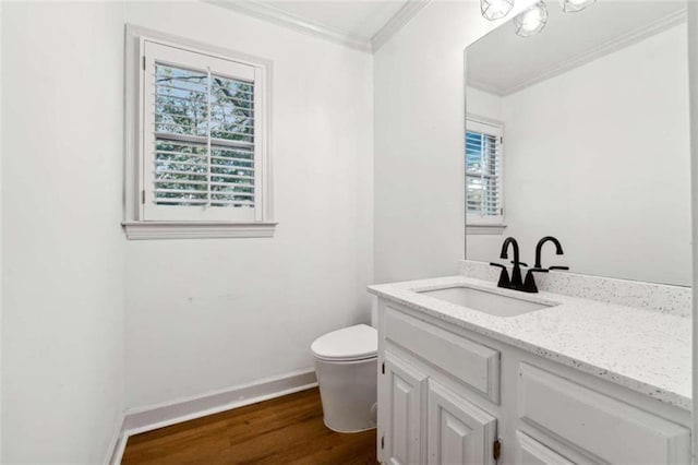 bathroom with crown molding, toilet, vanity, and hardwood / wood-style flooring