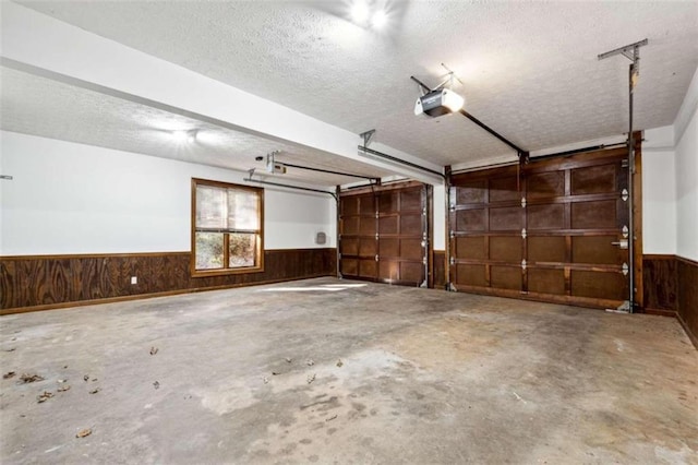 garage with wood walls and a garage door opener