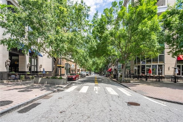 view of asphalt street featuring curbs, sidewalks, and a residential view