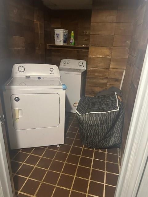 washroom with independent washer and dryer and wooden walls