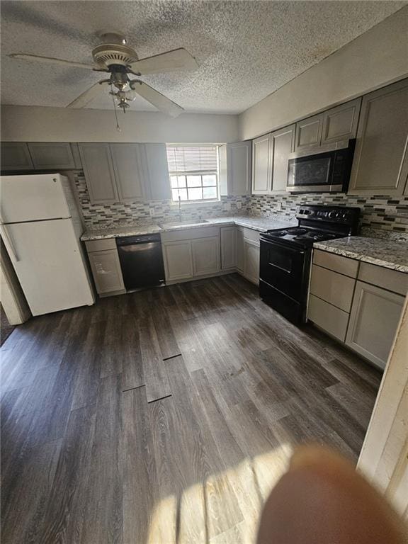 kitchen with dark hardwood / wood-style flooring, gray cabinets, and black appliances