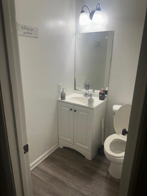 bathroom featuring vanity, hardwood / wood-style flooring, and toilet