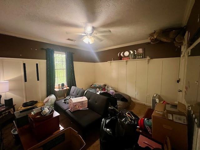 bedroom with ornamental molding, a ceiling fan, a textured ceiling, and visible vents