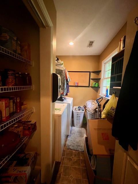laundry area featuring dark tile patterned flooring, separate washer and dryer, and laundry area