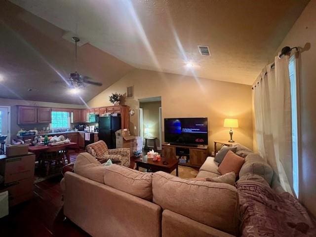 living room featuring visible vents, a ceiling fan, and vaulted ceiling