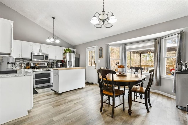 238 Brentwood Dr, Dallas, GA 30132 - dining area with a chandelier, lofted ceiling, and light wood-type flooring