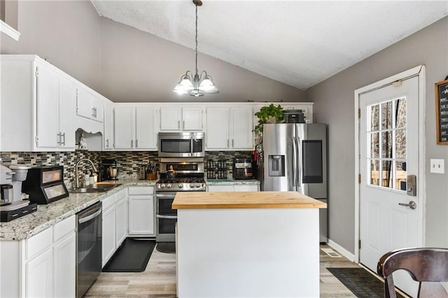 238 Brentwood Dr, Dallas, GA 30132 - kitchen with white cabinetry, hanging light fixtures, stainless steel appliances, lofted ceiling, and a kitchen island