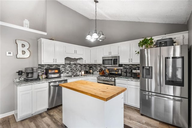 238 Brentwood Dr, Dallas, GA 30132 - kitchen featuring a center island, white cabinets, sink, decorative light fixtures, and stainless steel appliances