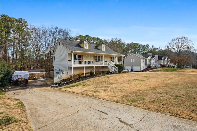 view of front of property featuring a porch, a garage, and a front lawn