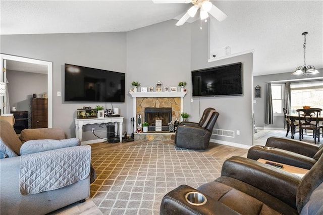 238 Brentwood Dr, Dallas, GA 30132 - living room featuring ceiling fan with notable chandelier, light hardwood / wood-style floors, a stone fireplace, and lofted ceiling