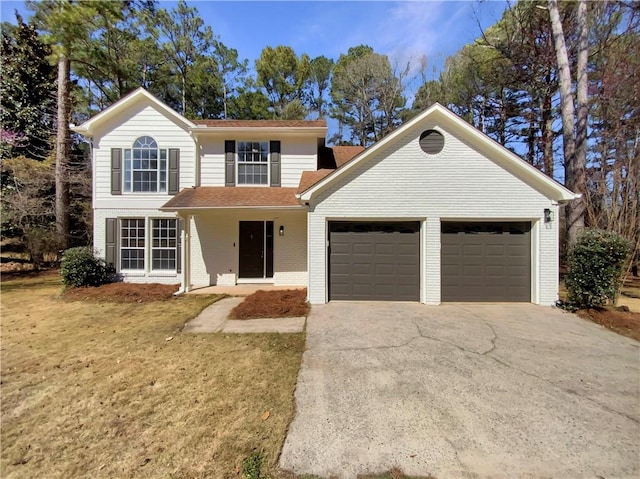 traditional-style home with a garage, a front lawn, brick siding, and driveway