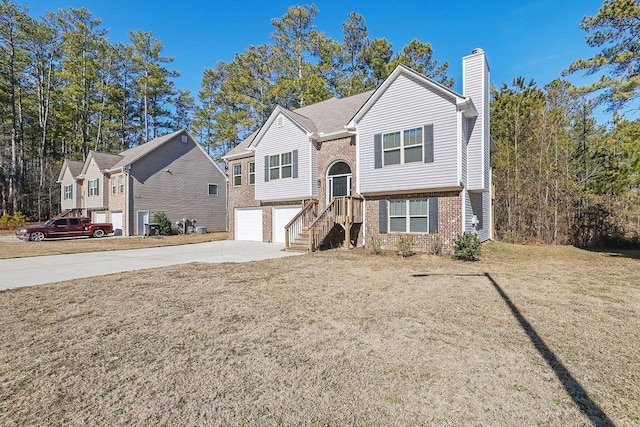 raised ranch with a front lawn and a garage