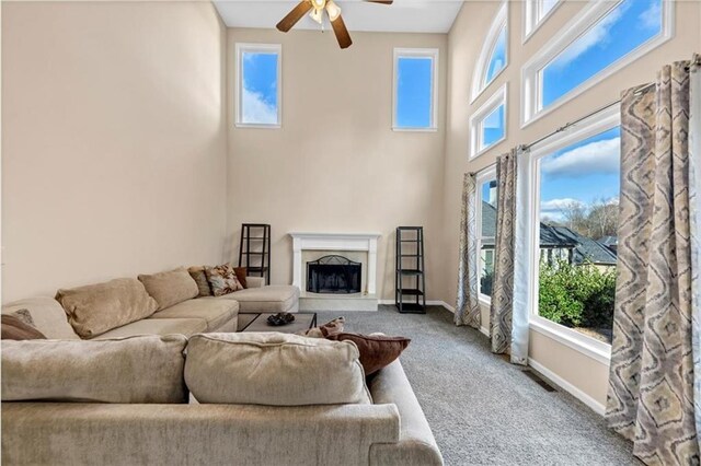 living room with carpet, ceiling fan, and a high end fireplace