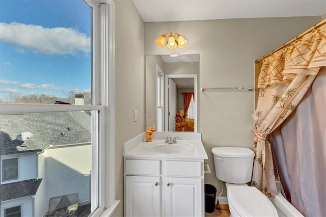 bathroom featuring a shower with curtain, vanity, a healthy amount of sunlight, and toilet