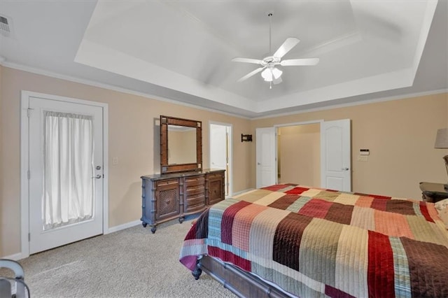 bedroom featuring ceiling fan, ornamental molding, light carpet, and a tray ceiling