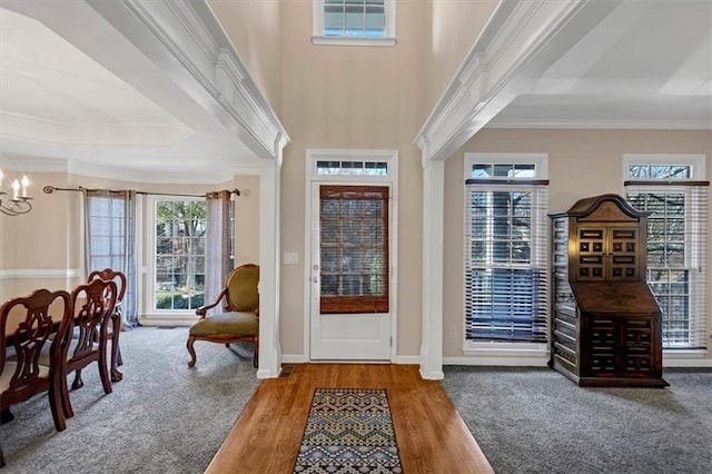 foyer entrance with an inviting chandelier, crown molding, and light hardwood / wood-style flooring