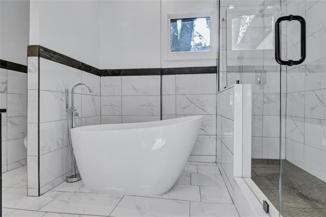 bathroom featuring independent shower and bath and tile walls