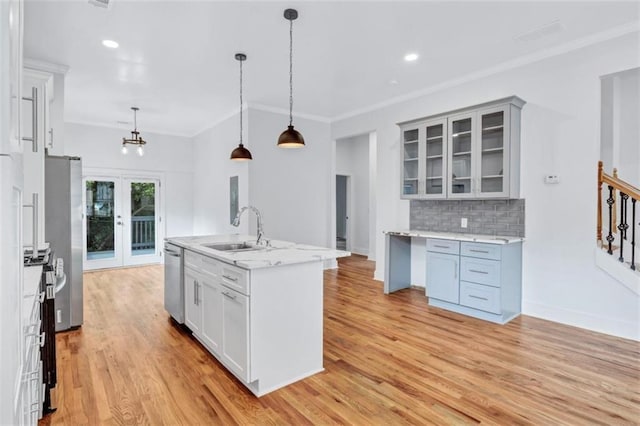 kitchen featuring crown molding, decorative backsplash, sink, pendant lighting, and stainless steel appliances