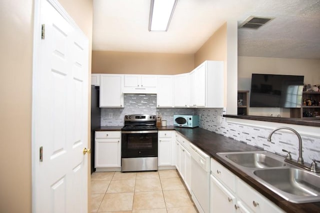 kitchen with a sink, dark countertops, decorative backsplash, and white appliances