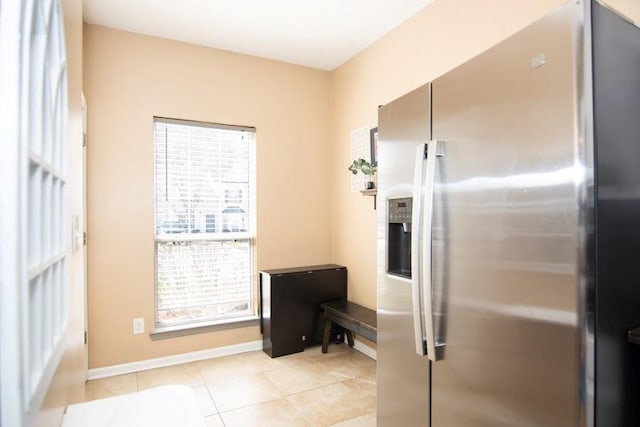 doorway with baseboards and light tile patterned flooring
