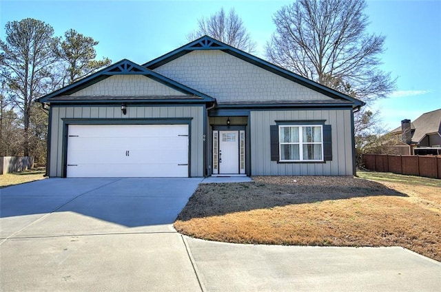 view of front of property with a garage, concrete driveway, board and batten siding, and fence