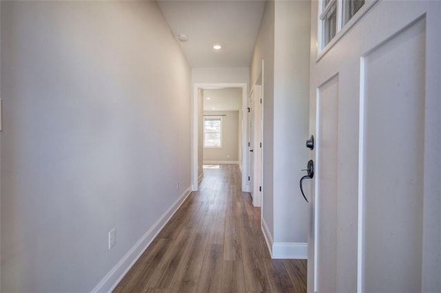 corridor featuring recessed lighting, dark wood-style flooring, and baseboards