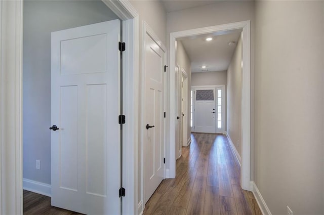 hallway featuring dark wood-style floors and baseboards