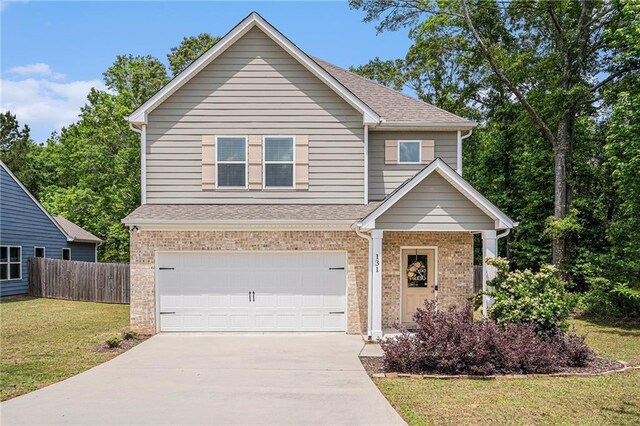 view of front facade featuring a front yard, brick siding, fence, concrete driveway, and an attached garage