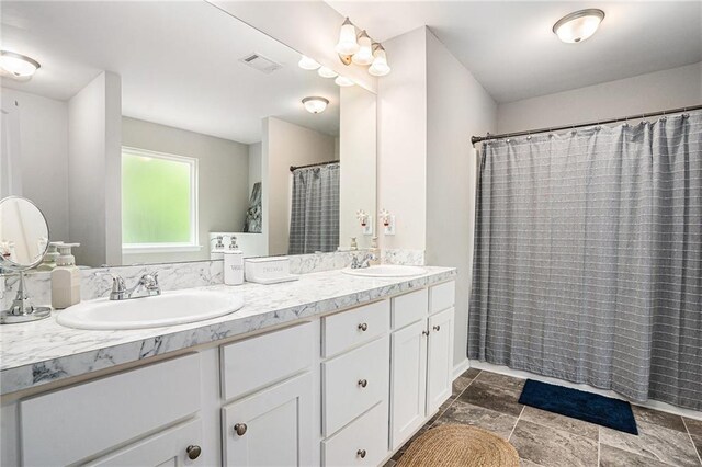 full bathroom with a sink, curtained shower, double vanity, and visible vents