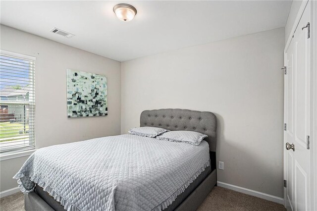 bedroom featuring baseboards, visible vents, multiple windows, and carpet