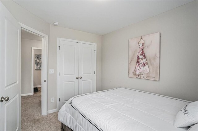 bedroom with carpet floors, baseboards, and a closet
