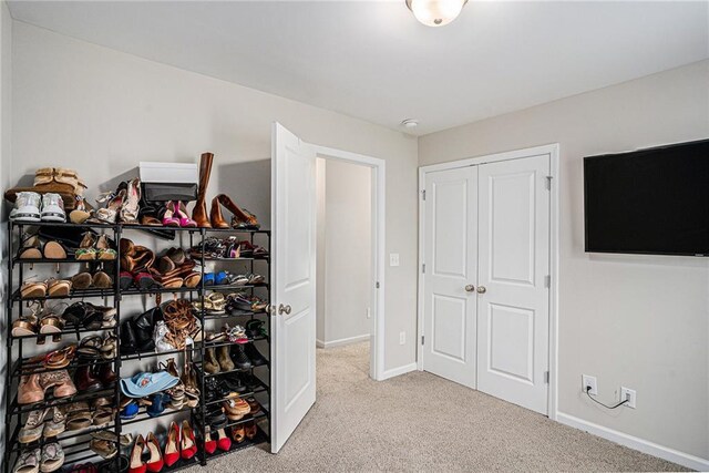 bedroom with baseboards, carpet, and a closet