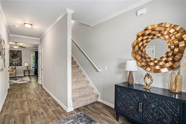 stairs with baseboards, ornamental molding, and wood finished floors