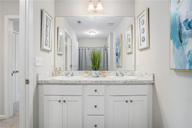 bathroom with visible vents, a sink, and double vanity