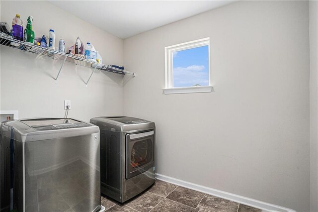 washroom with laundry area, washer and clothes dryer, and baseboards